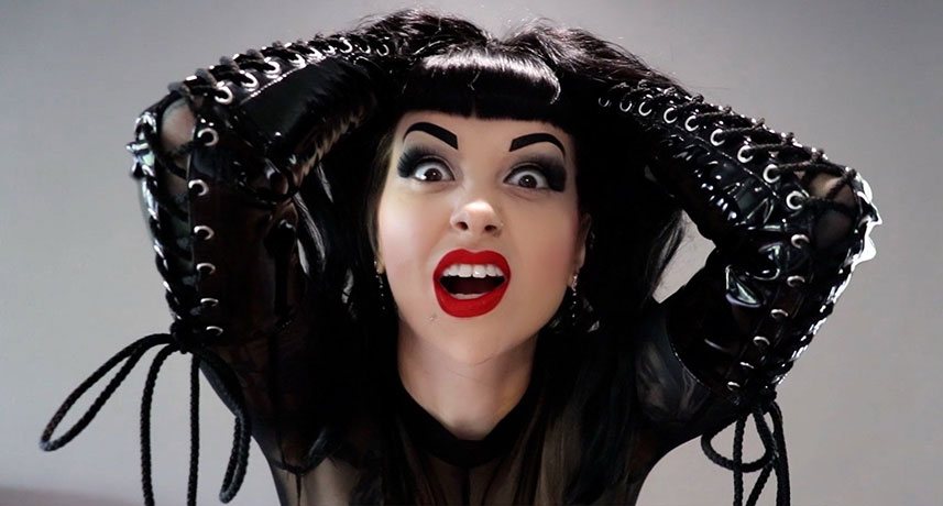 Lady Vi wearing black PVC gloves screams in frustration while pulling her hair